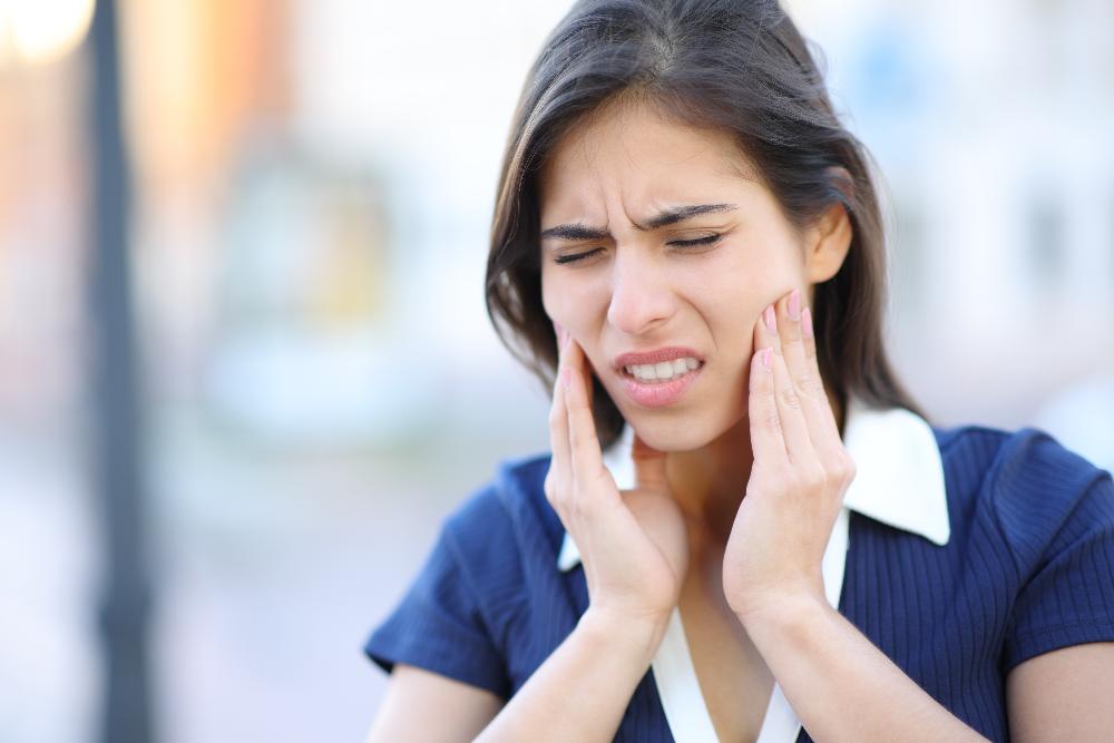 woman in pain holding mouth with two hands | sedation dentistry bellevue tn
