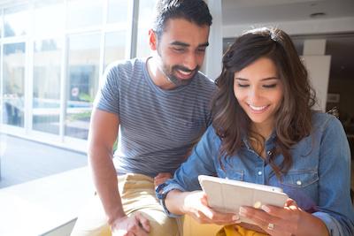 young couple looking at computer | affordable dental implants nashville tn