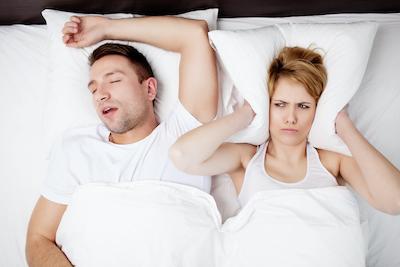 woman sleeping next to loud snoring | sleep apnea dentist bellevue