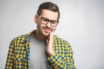 man in pain holding jaw | emergency dentist bellevue tn