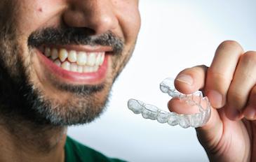 patient holding clear plastic aligner | orthodontics bellevue tn
