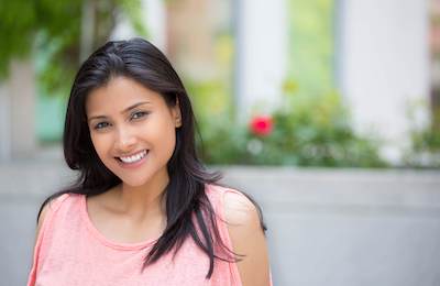 woman in pink shirt smiling | cosmetic dentist bellevue tn