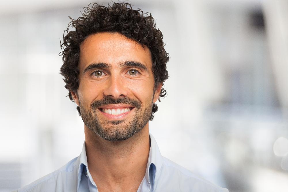 man with curly hair smiling | cosmetic dentist bellevue tn