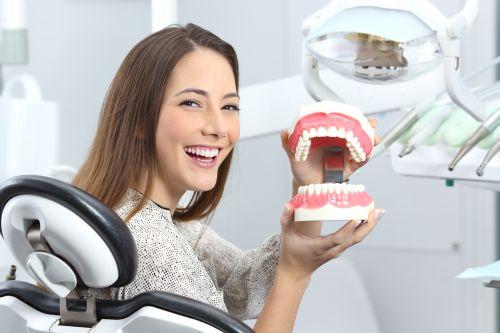 woman smiling holding mouth model | dentist bellevue tn